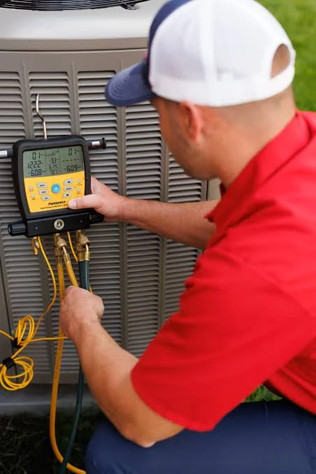 Technician checking HVAC pressures with a digital diagnostic gauge