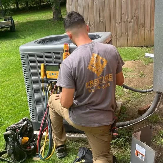Technician checking outdoor heating and cooling system performance
